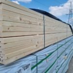 Stacked wooden beams with C24 marking outdoors.